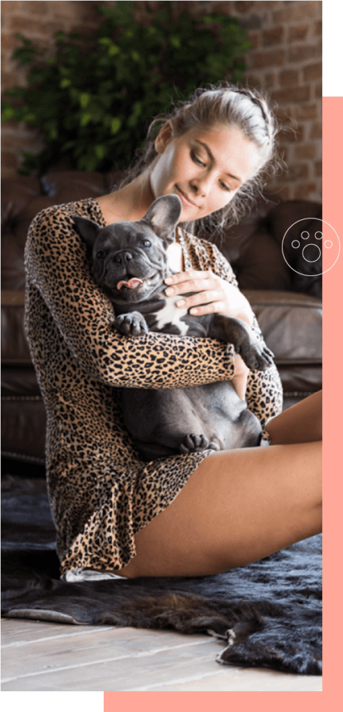a woman setting and holding a french bulldog